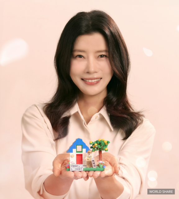 월드쉐어 친선대사 배우 유선이 ‘구해줘 그룹홈즈’ 캠페인 굿즈를 들고 환히 웃고 있다